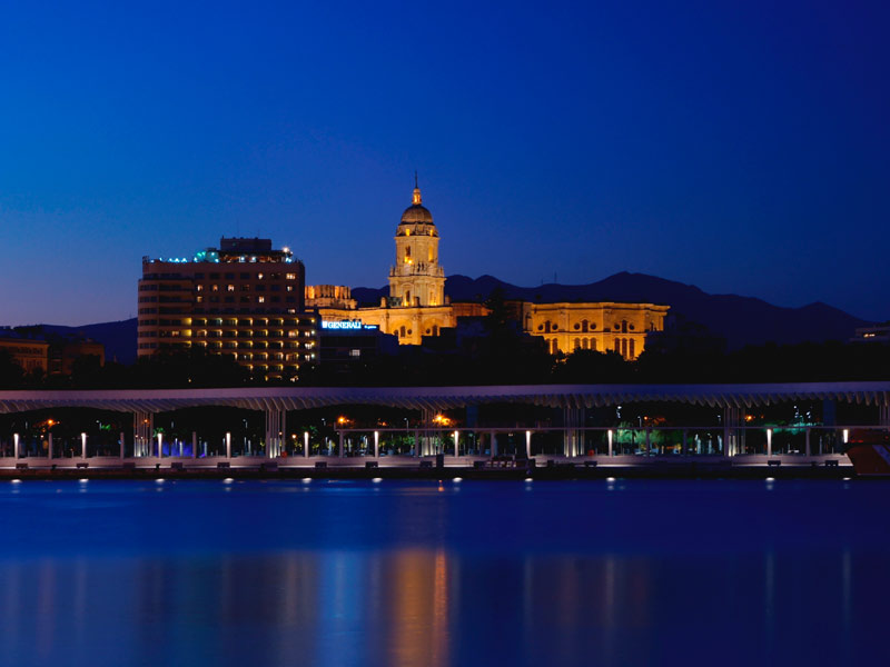 Beleuchtete Skyline von Málaga bei Nacht mit Blick auf Kathedrale und Hafen