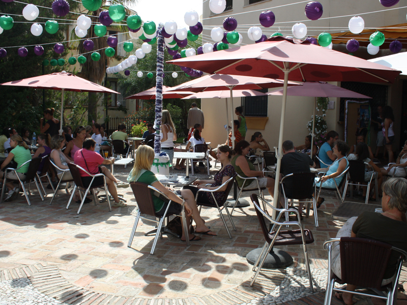 Schulcafé mit Teilnehmenden bei gemeinsamer Pause unter Sonnenschirmen