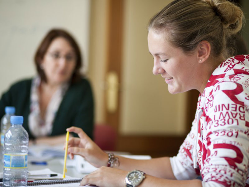 Teilnehmerin konzentriert beim Spanischlernen im Unterricht