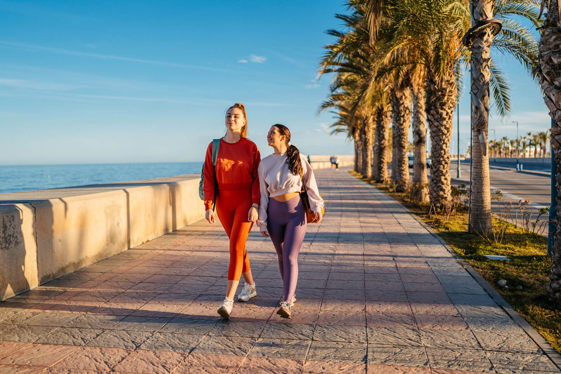 Zwei Teilnehmerinnen spazieren an der Promenade entlang, Freizeitaktivität während der Sprachreise