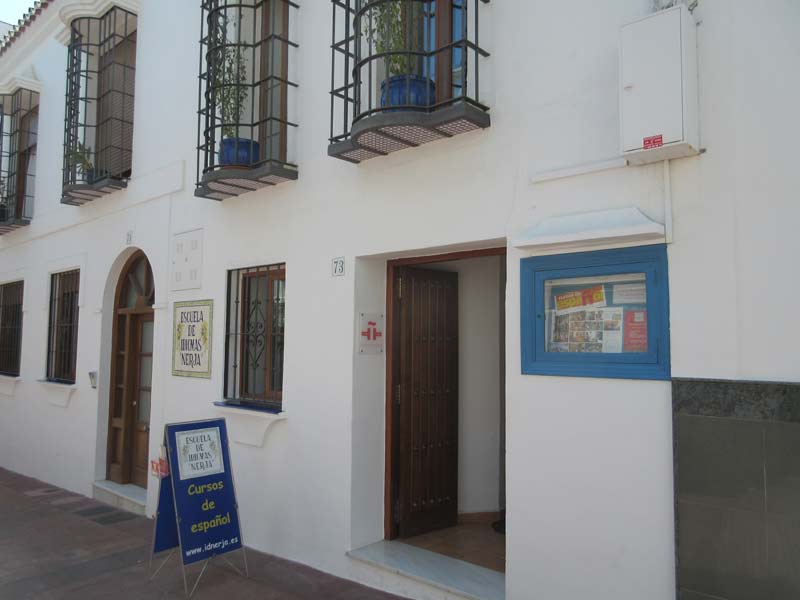 Eingangsbereich der Escuela de Idiomas Nerja mit Hinweisschild zu Spanischkursen
