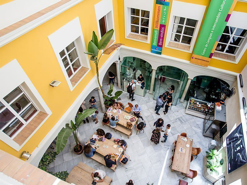 Gemeinschaftsbereich im hellen Patio der Sprachschule in Sevilla