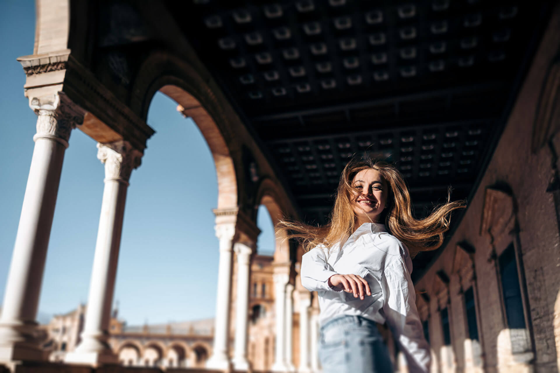 Teilnehmerin der Sprachreise genießt die Sonne und Architektur auf dem Plaza de España in Sevilla