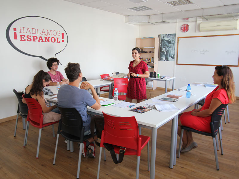 Kleine Gruppe beim Spanischunterricht mit engagierter Lehrkraft