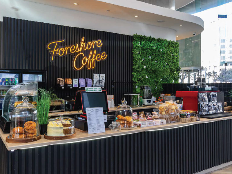 Modernes Café im Gebäude der Sprachreise-Unterkunft in Kapstadt mit Snacks und Kaffeeangebot.