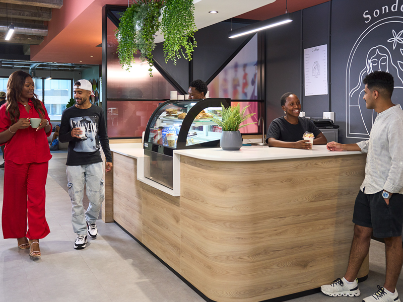 Cafetería de la escuela con estudiantes conversando y tomando café