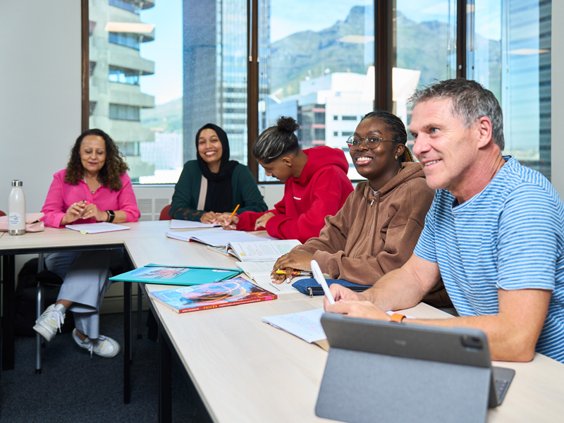 Estudiantes aprendiendo en un aula luminosa con vistas a Ciudad del Cabo