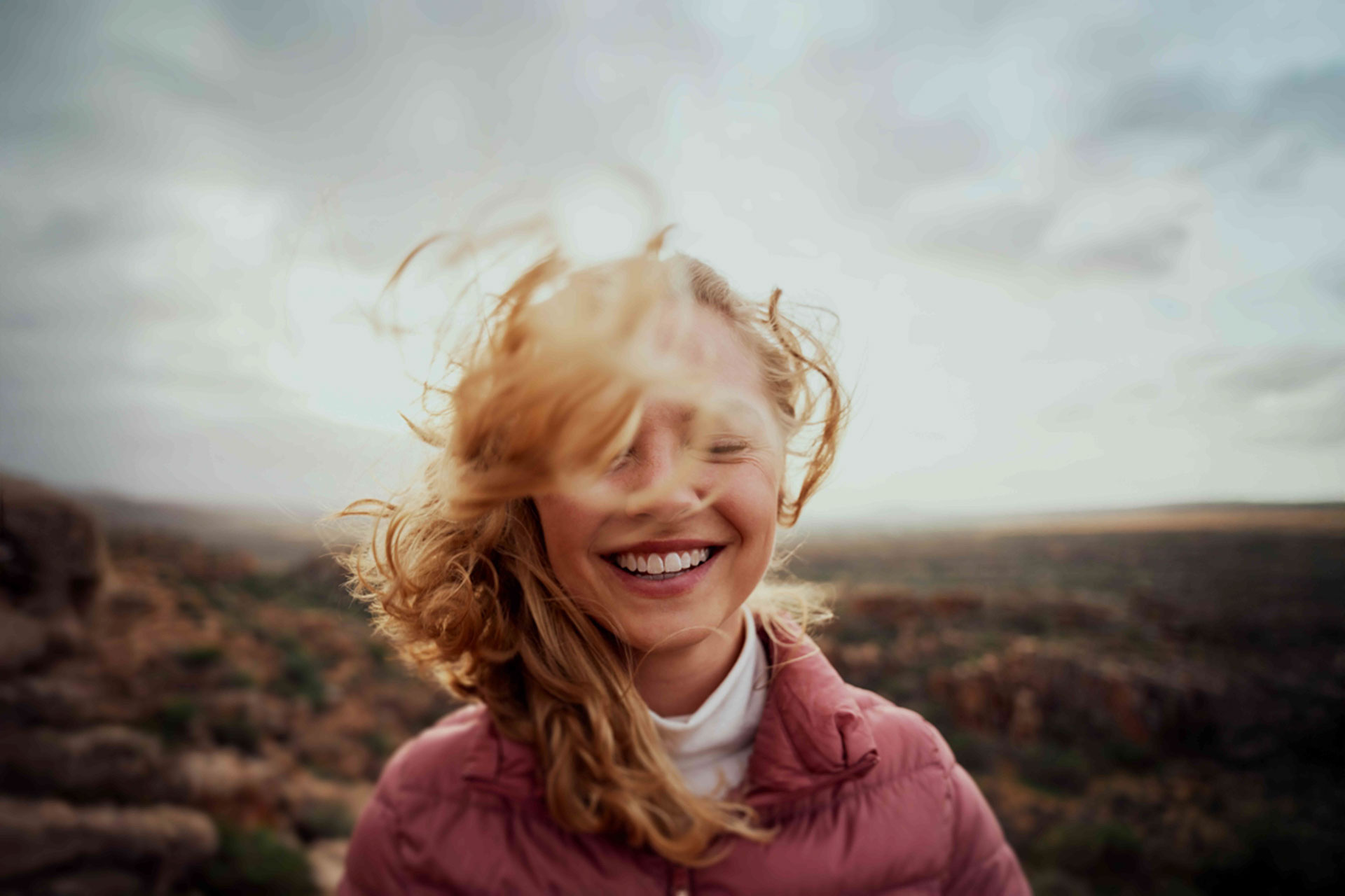 Lächelnde Teilnehmerin einer Sprachreise in Südafrika mit Blick auf die Natur Kapstadts