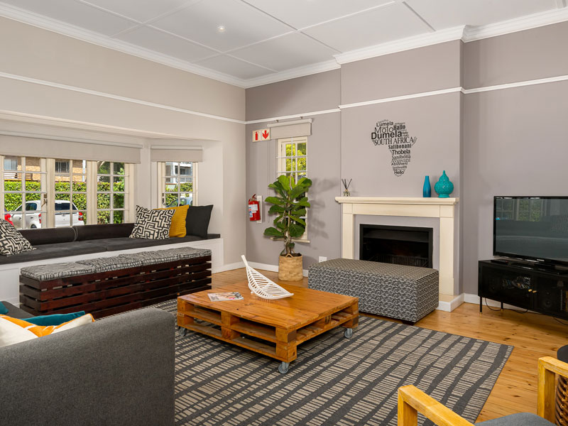 Spazio comune confortevole con divano, camino e TV per studenti di lingue