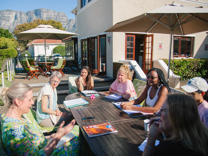 Lezioni di lingua sulla terrazza soleggiata della scuola a Città del Capo, con vista sulla natura circostante.