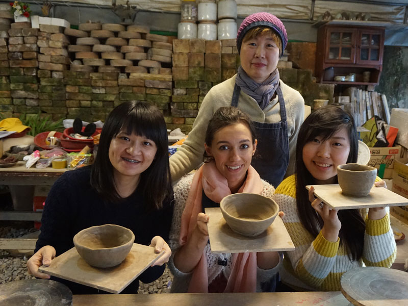 Teilnehmende präsentieren selbstgetöpferte Schalen in einem Keramikkurs
