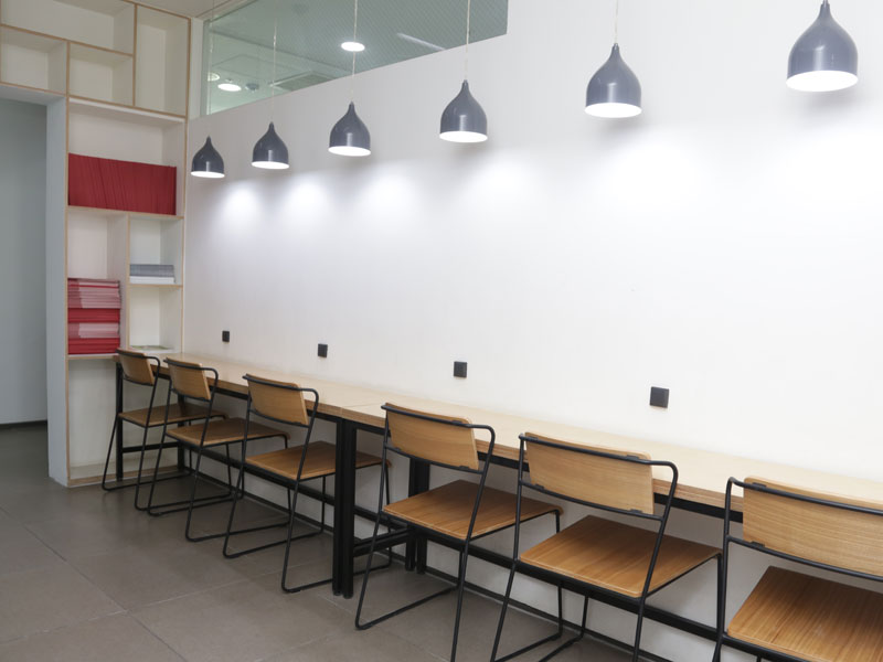 Moderner Lernbereich mit langen Tischen und Hängelampen in der Lexis Korea Busan