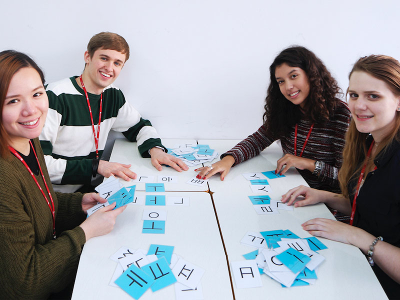Gruppe Lernender arbeitet mit koreanischen Schriftzeichen im Unterricht