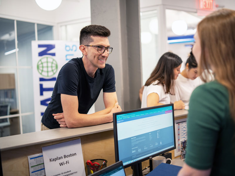 Sprachstudent im Gespräch mit Mitarbeiterin der Kaplan Boston