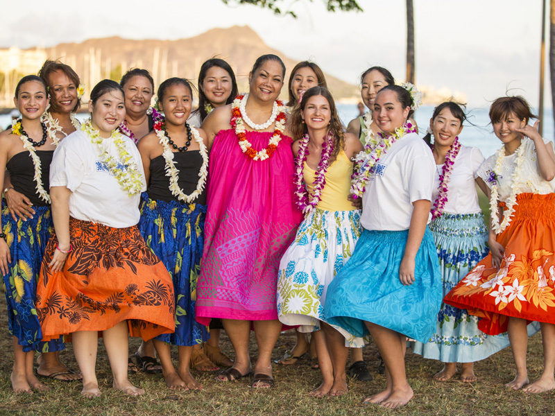 Hula-Tanzgruppe in traditionellen Kleidern am Strand von Honolulu mit Blick auf Diamond Head