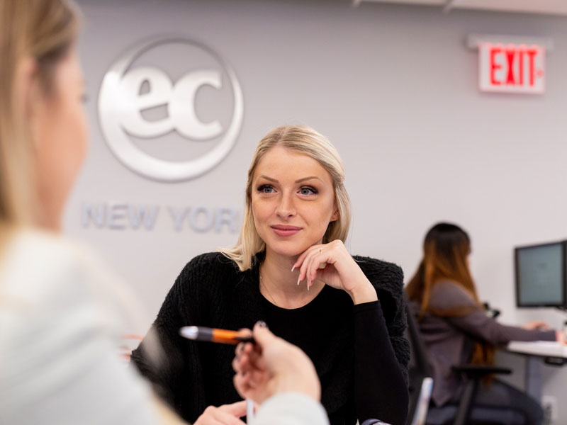 Sprachschülerin im Gespräch mit einer Mitschülerin im Empfangsbereich der EC New York Sprachschule