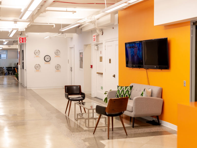 Wartebereich der EC New York Sprachschule mit Sitzmöbeln und Fernseher