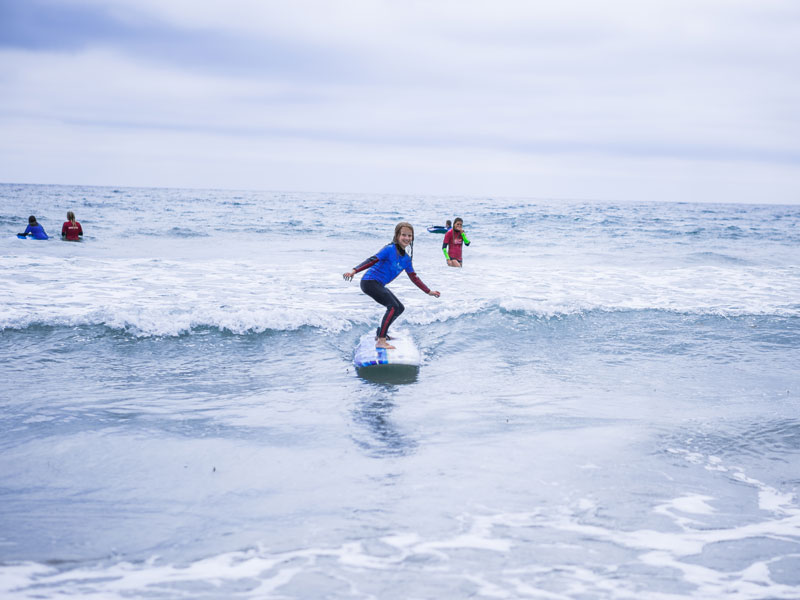 Sprachschülerin surft am Strand von San Diego während des CEL Summer Camps
