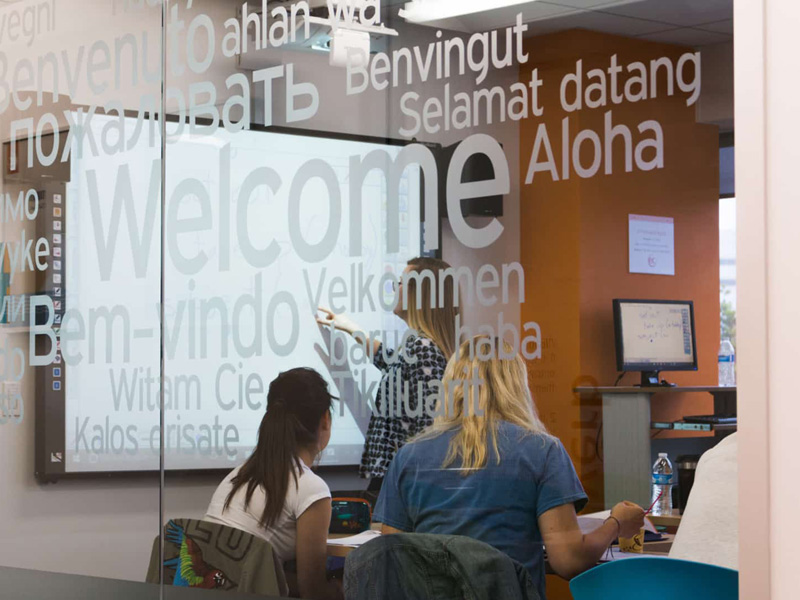 Unterricht an der EC Santa Monica Sprachschule durch Glaswand mit Willkommensschriftzügen gesehen