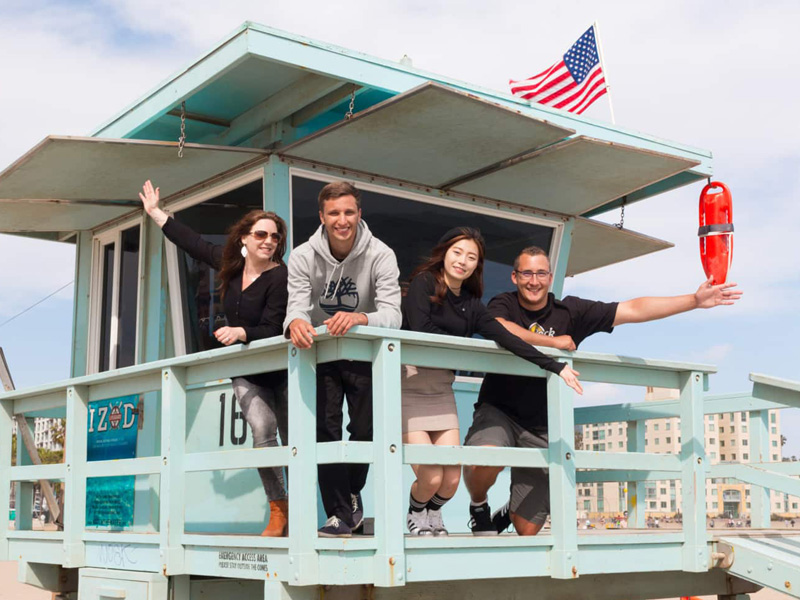 Sprachschülergruppe am Strand von Santa Monica vor typischem Lifeguard-Haus