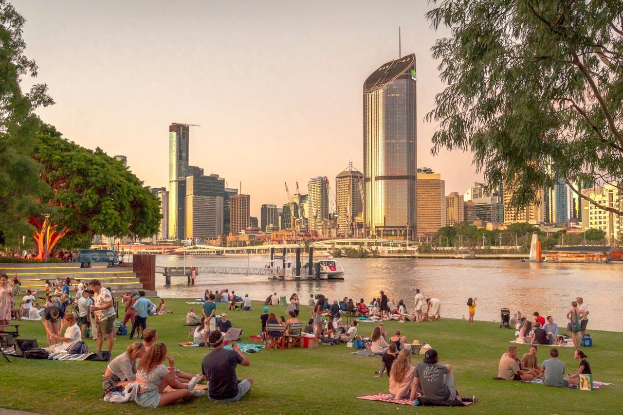 Picknick auf Rasen mit Skylineblick, Englisch lernen in der Gruppe nach dem Unterricht.