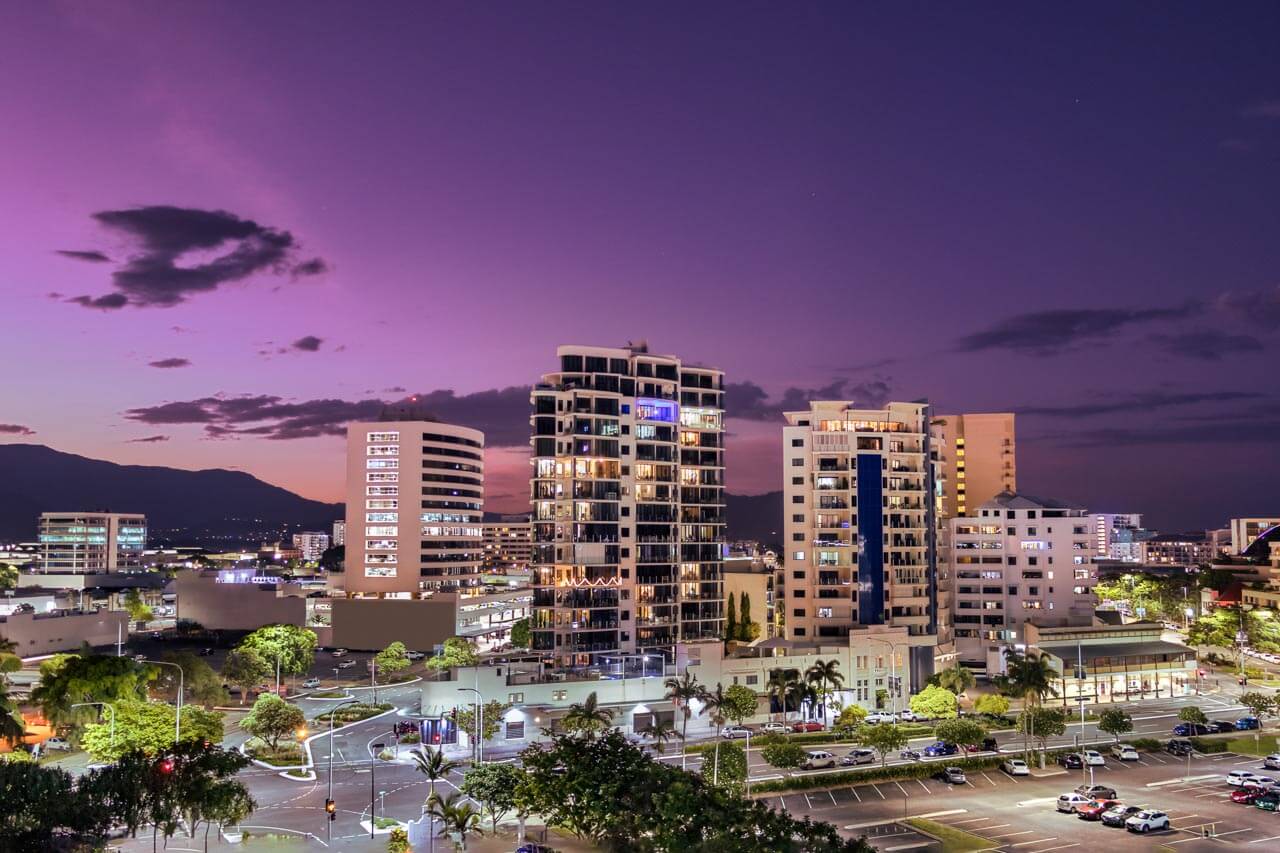 Skyline bei Abendlicht mit Bergen im Hintergrund in Cairns. Sprachkurs in moderner Stadt.