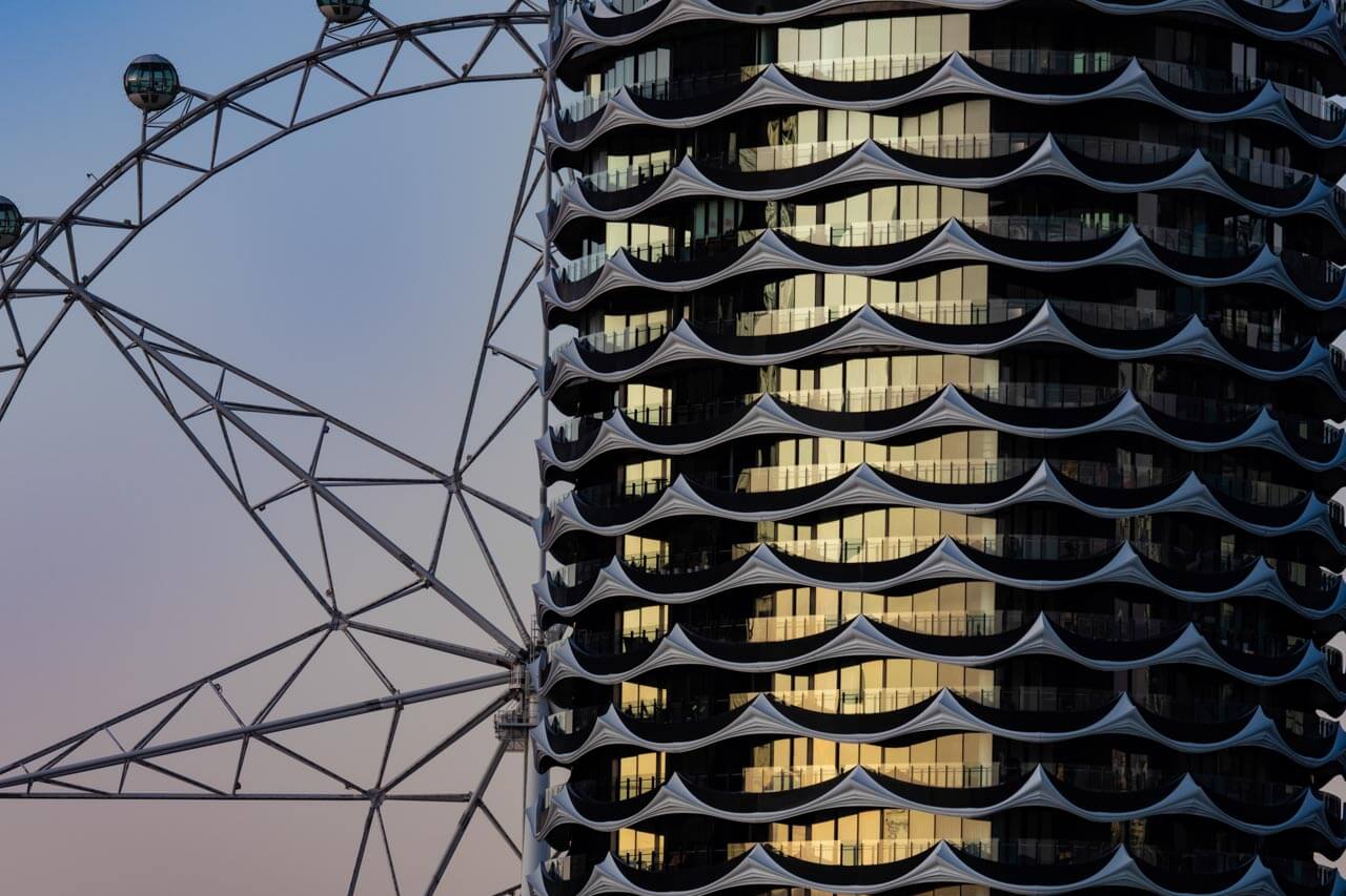 Riesenrad neben moderner Fassade, Konversation üben zu Stadtarchitektur.