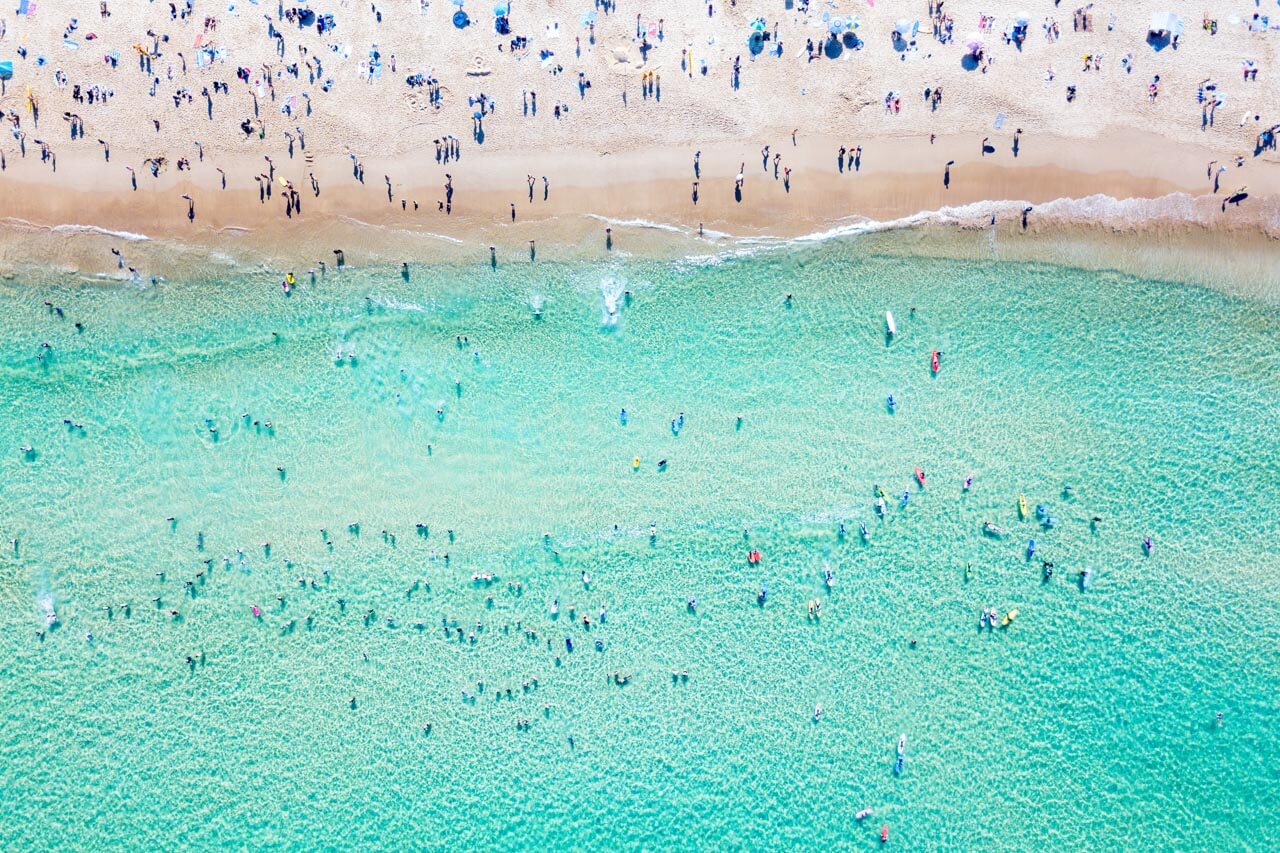 Luftaufnahme von Strand und Badenden, Hörverstehen üben mit Alltagsenglisch am Wasser.