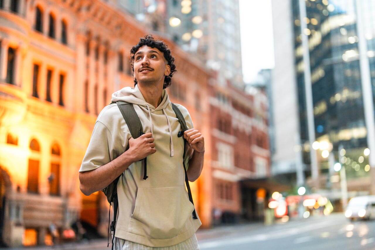 Person mit Rucksack erkundet die Stadt am Abend, Sprachreise Australien.