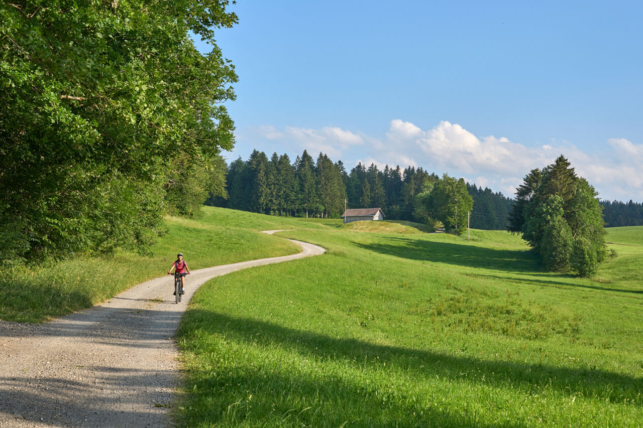 Radfahrer auf kurvigem Schotterweg, Hörverstehen und Wegbeschreibungen im Deutschkurs.