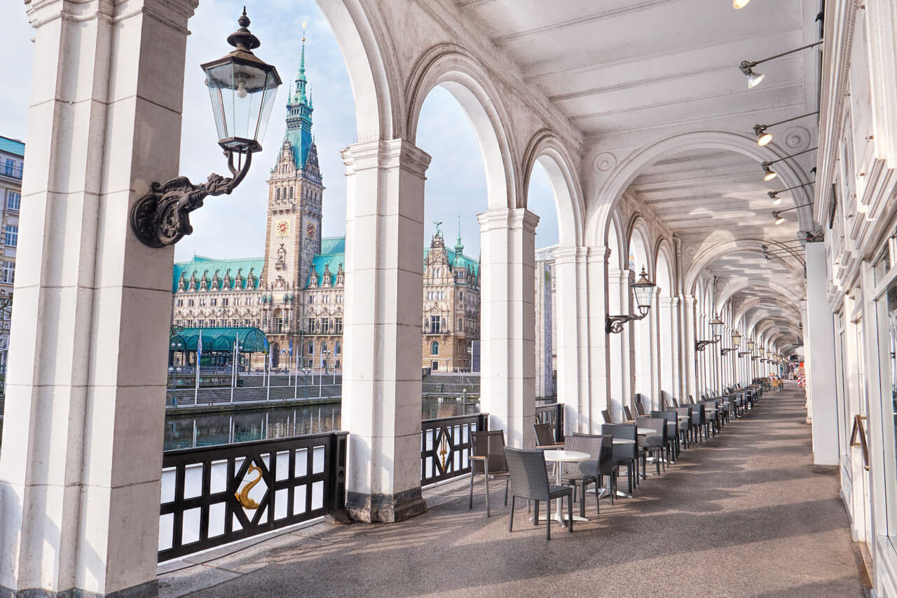 Blick durch die Alsterarkaden auf das Rathaus mit Caféterrassen