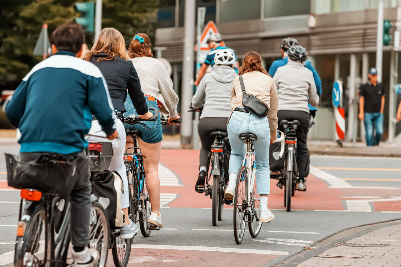 Gruppe von Radfahrerinnen und Radfahrern an einer Kreuzung – Alltagsverkehr in der Fahrradstadt.