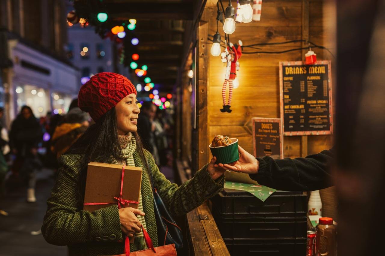 Person am Wintermarkt in Cambridge am Snackstand Englisch im Alltag anwenden während der Sprachreise