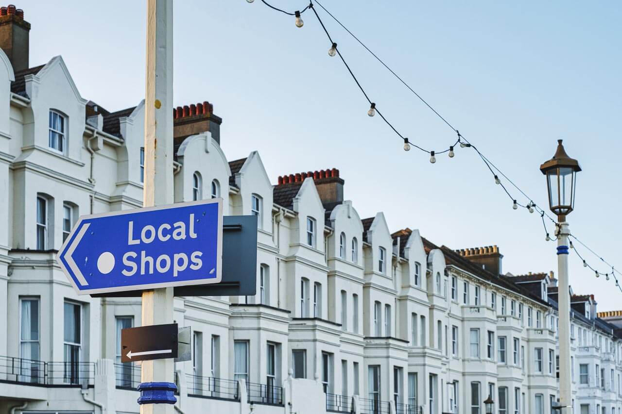 Wegweiser Local Shops an der Promenade in Eastbourne Konversation üben beim Einkaufen nach dem Sprachkurs