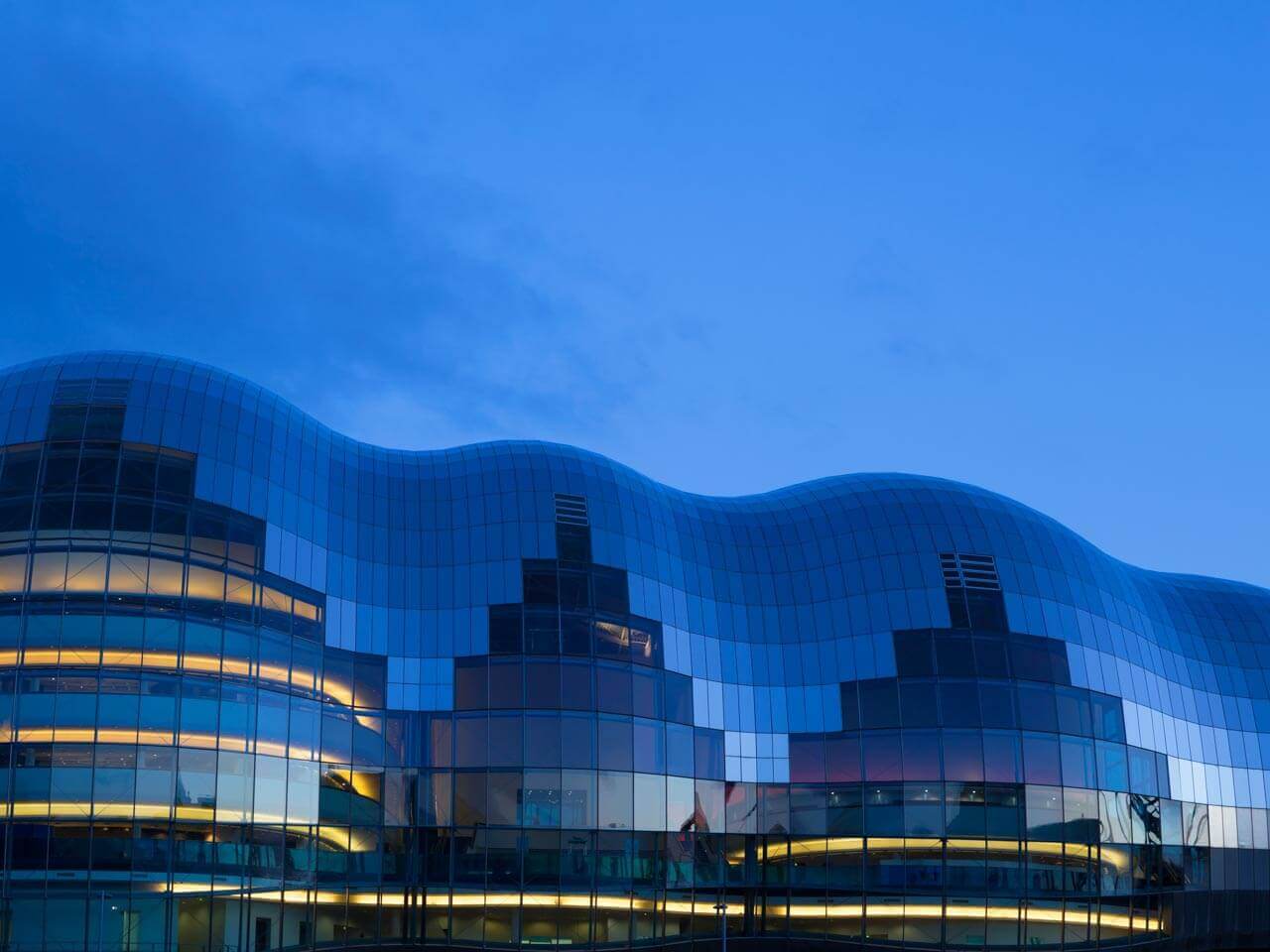 Moderne Glasfassade der Sage Gateshead in der blauen Stunde Grammatik im Kontext im Englischkurs