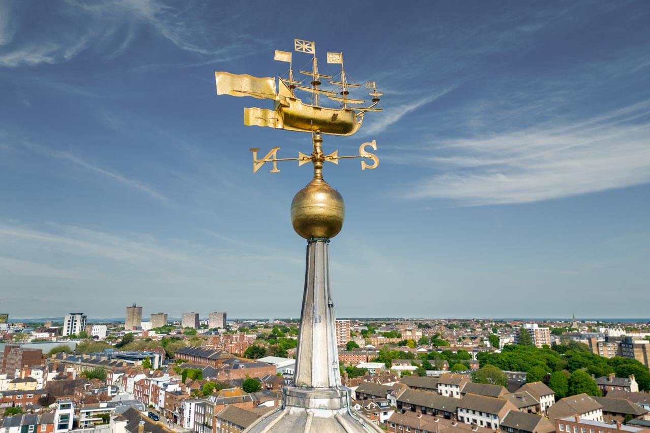 Blick über Portsmouth mit goldener Schiffs-Wetterfahne Wortschatz zur Seefahrt erweitern im Englischkurs