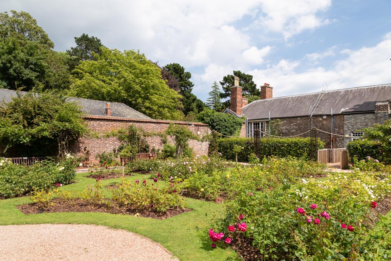 Historischer Rosengarten am Cottage mit Backsteinmauer Grammatik im Kontext im Englischkurs