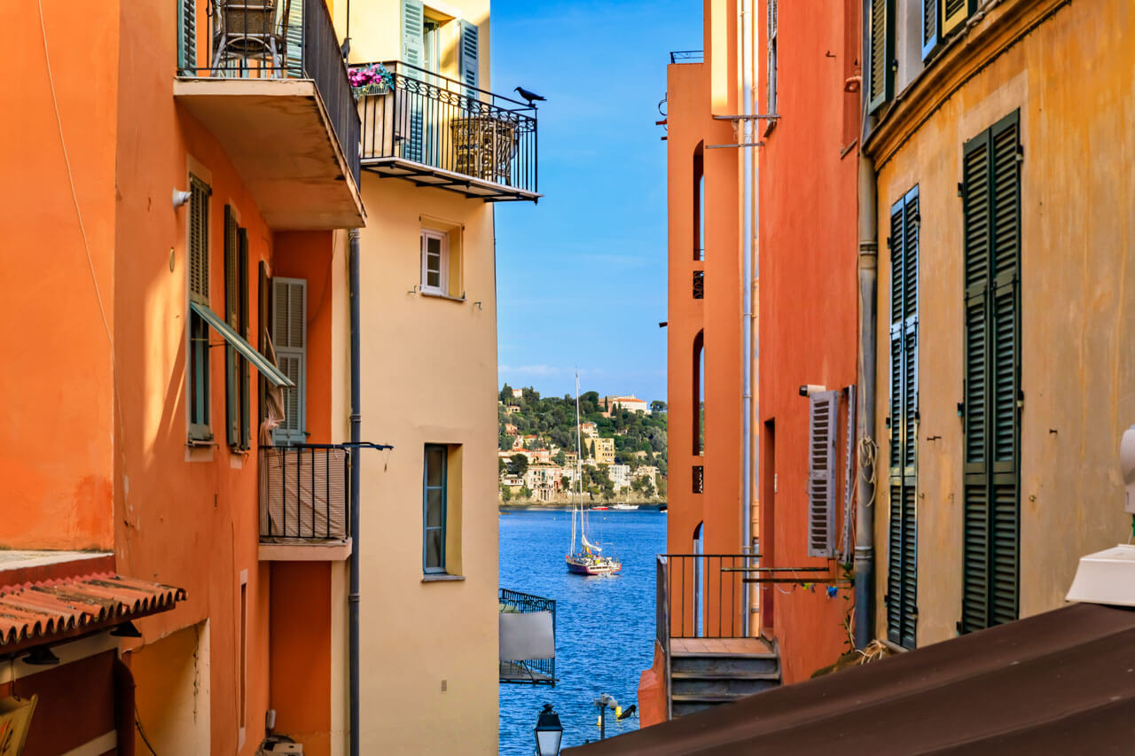 Bunter Fassadengang mit Blick aufs Meer Hörverstehen trainieren auf Sprachreise