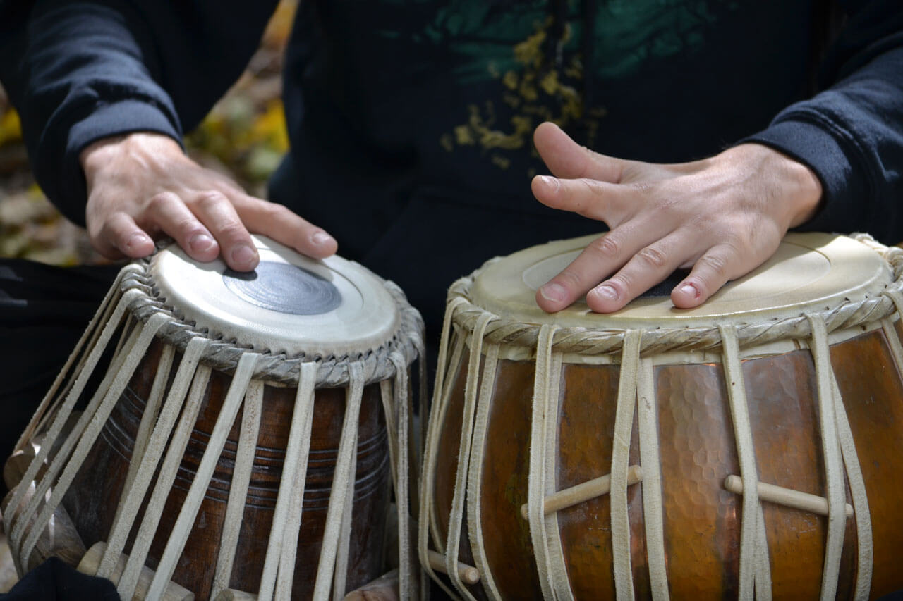 Hände spielen auf Gwo Ka Trommeln Rhythmus erleben Konversation üben im Französischkurs