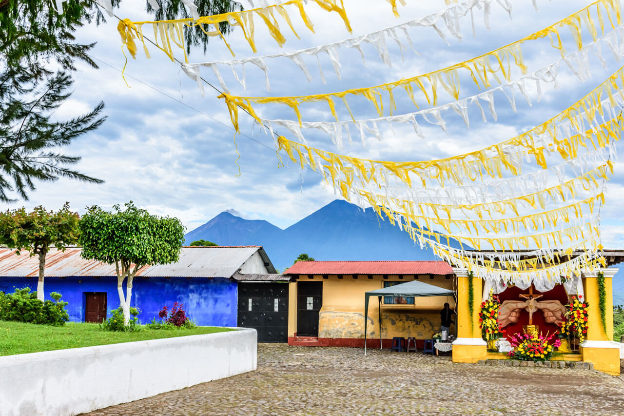 Dorfplatz mit gelb weißen Wimpeln und Hausaltar bei Antigua Sprachreise Spanisch lernen Hörverstehen im Alltag.