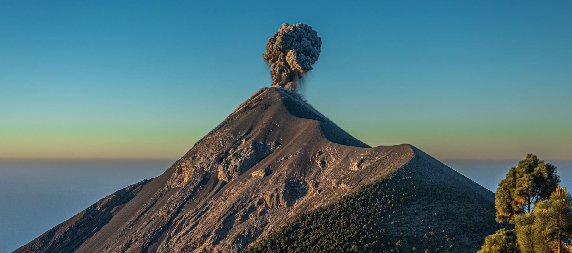 Aktiver Vulkan mit Aschewolke Grammatik trainieren während der Sprachreise