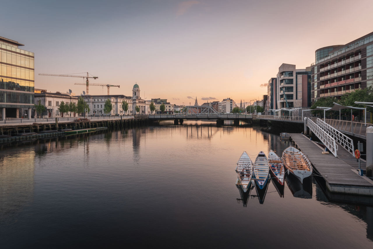 Abend am River Lee mit Ruderbooten und Rathaus in Cork Hörverstehen üben auf Exkursion