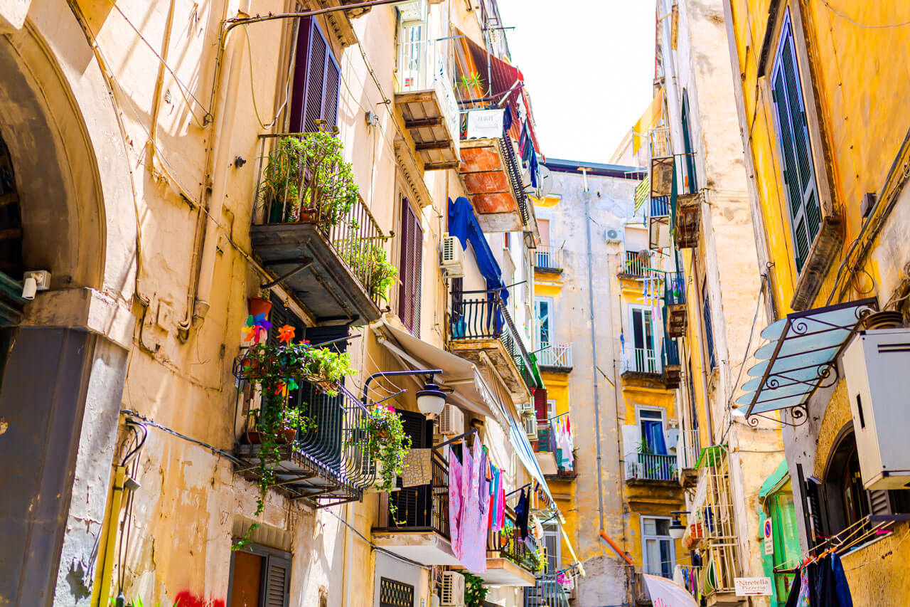 Bunte Gasse mit Balkonen und Wäsche Konversation üben im Alltag während der Sprachreise