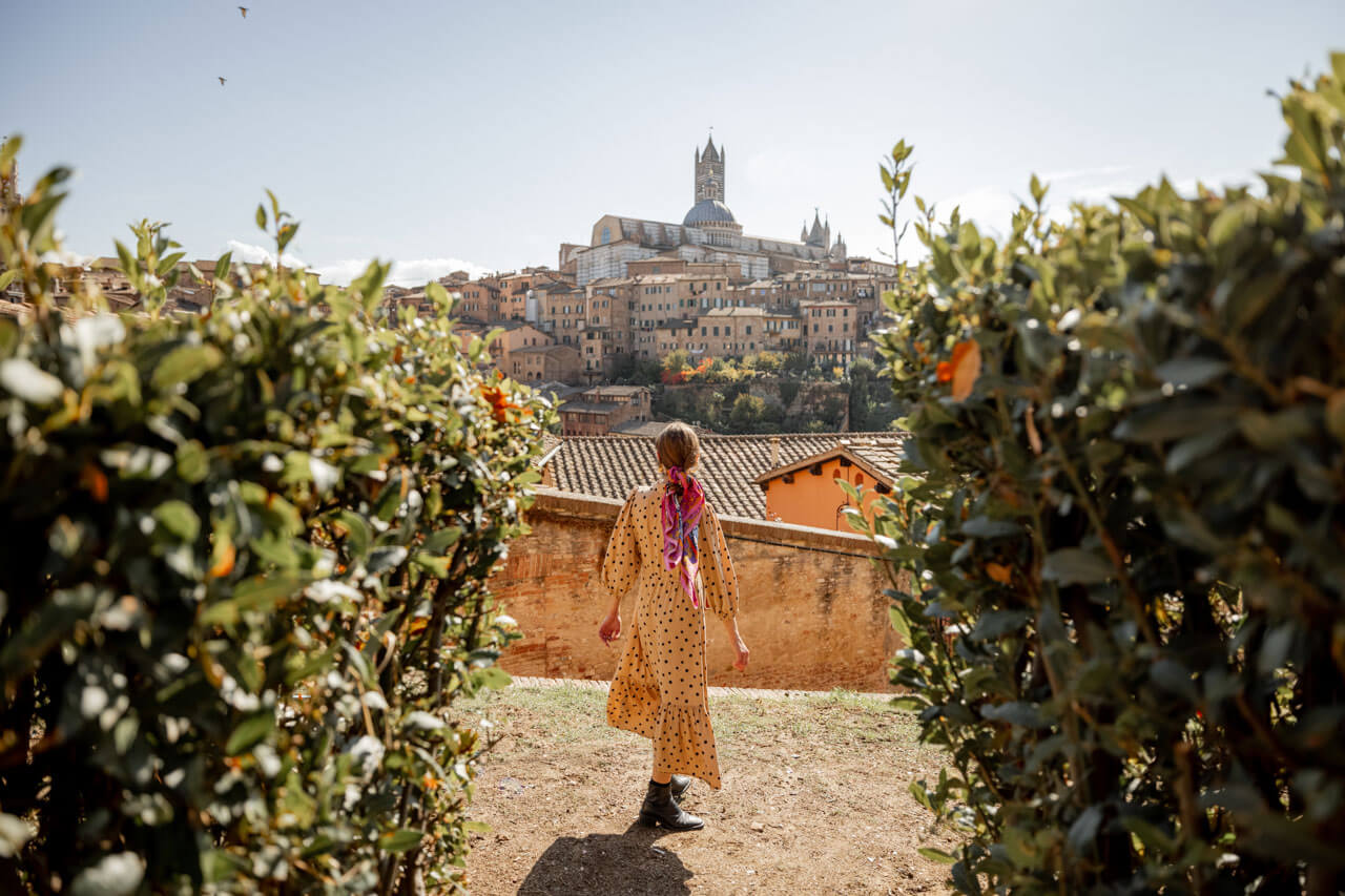 Frau blickt auf die Skyline von Siena Konversation üben während der Sprachreise
