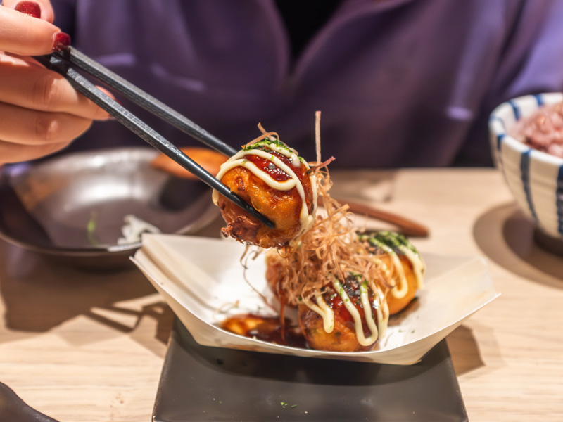 Probando comida callejera típica japonesa durante un viaje de idiomas con el profesor en Japón