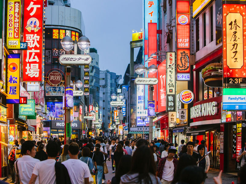 Calle animada de Tokio por la noche con luces de neón durante el curso de idiomas