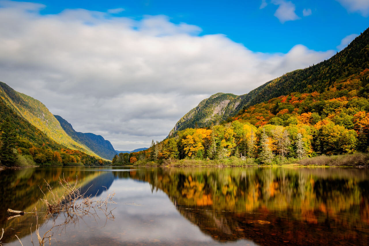 Spiegelsee zwischen bunten Berghängen, ruhige Kulisse für Sprachreisen und Schreibtraining