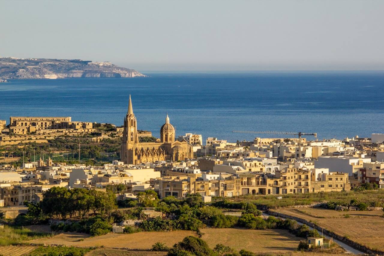 Blick über Ghajnsielem mit Kirche und Küste Konversation üben beim Stadtspaziergang