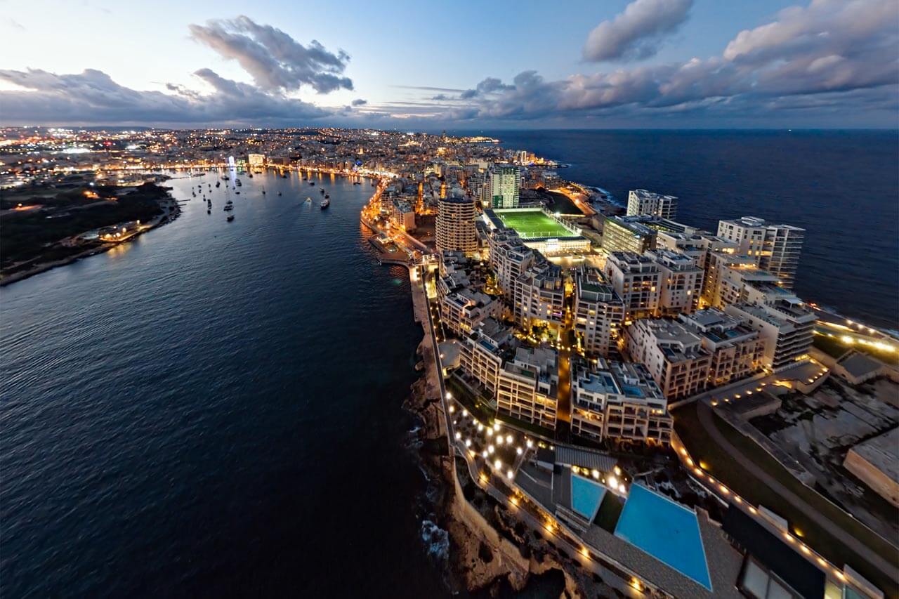 Sliema bei Nacht mit beleuchtetem Ufer und Fort Tigné Hörverstehen üben beim Abendspaziergang