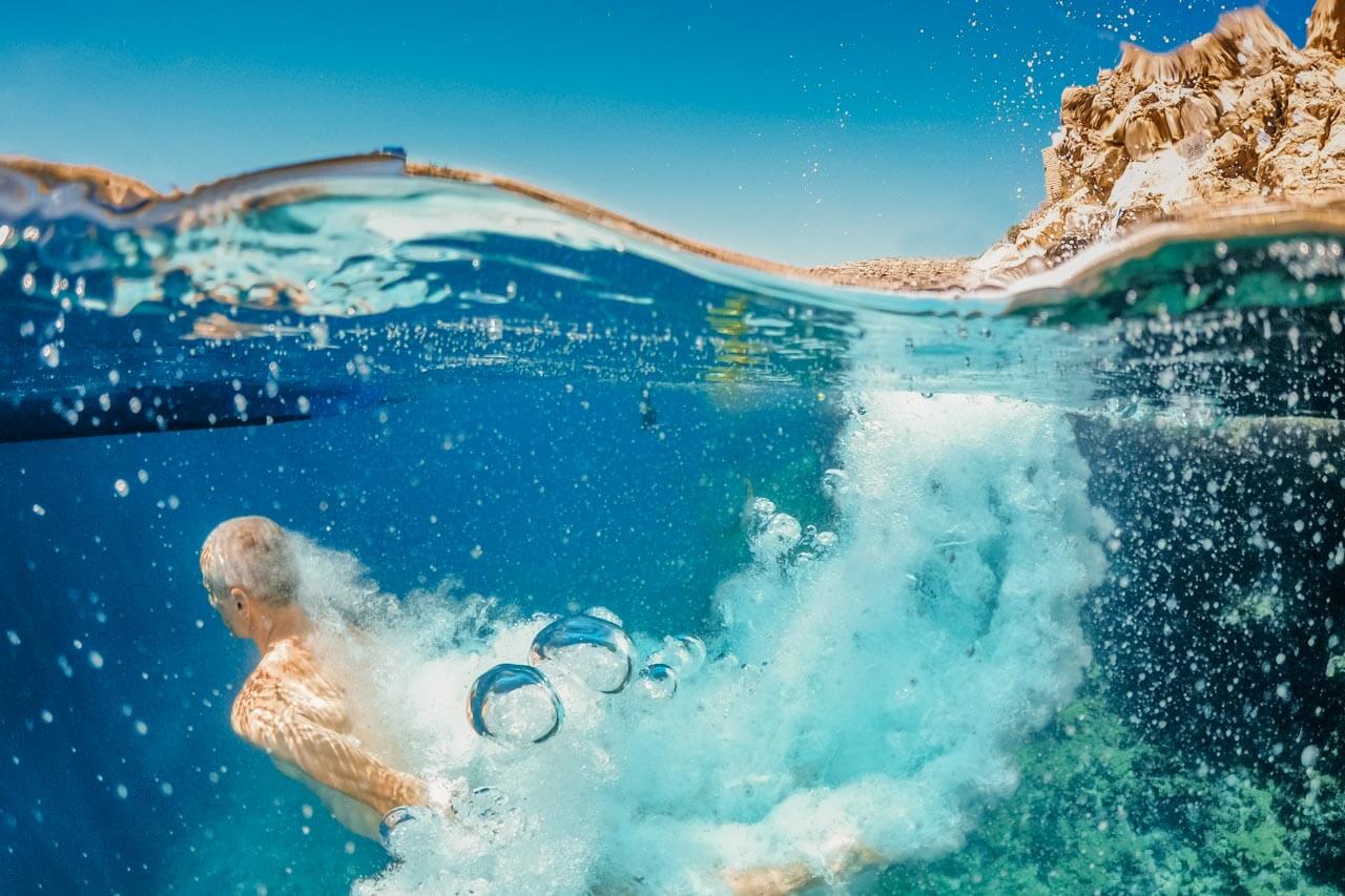 Kopfsprung ins glasklare Wasser; Blasen perlen zur Oberfläche. Small Talk über Sport und Hobbys üben